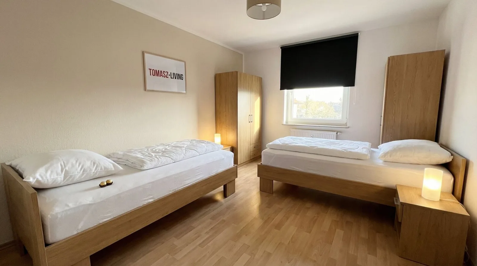 Zweibettzimmer mit zwei Holzbetten und Kleiderschrank