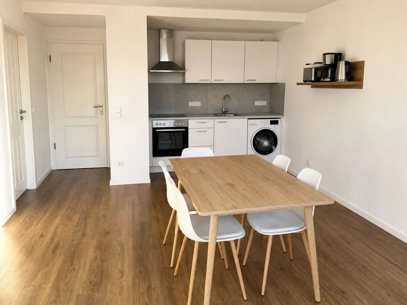 Offene Wohnküche mit Backofen, Waschmaschine und Esstisch