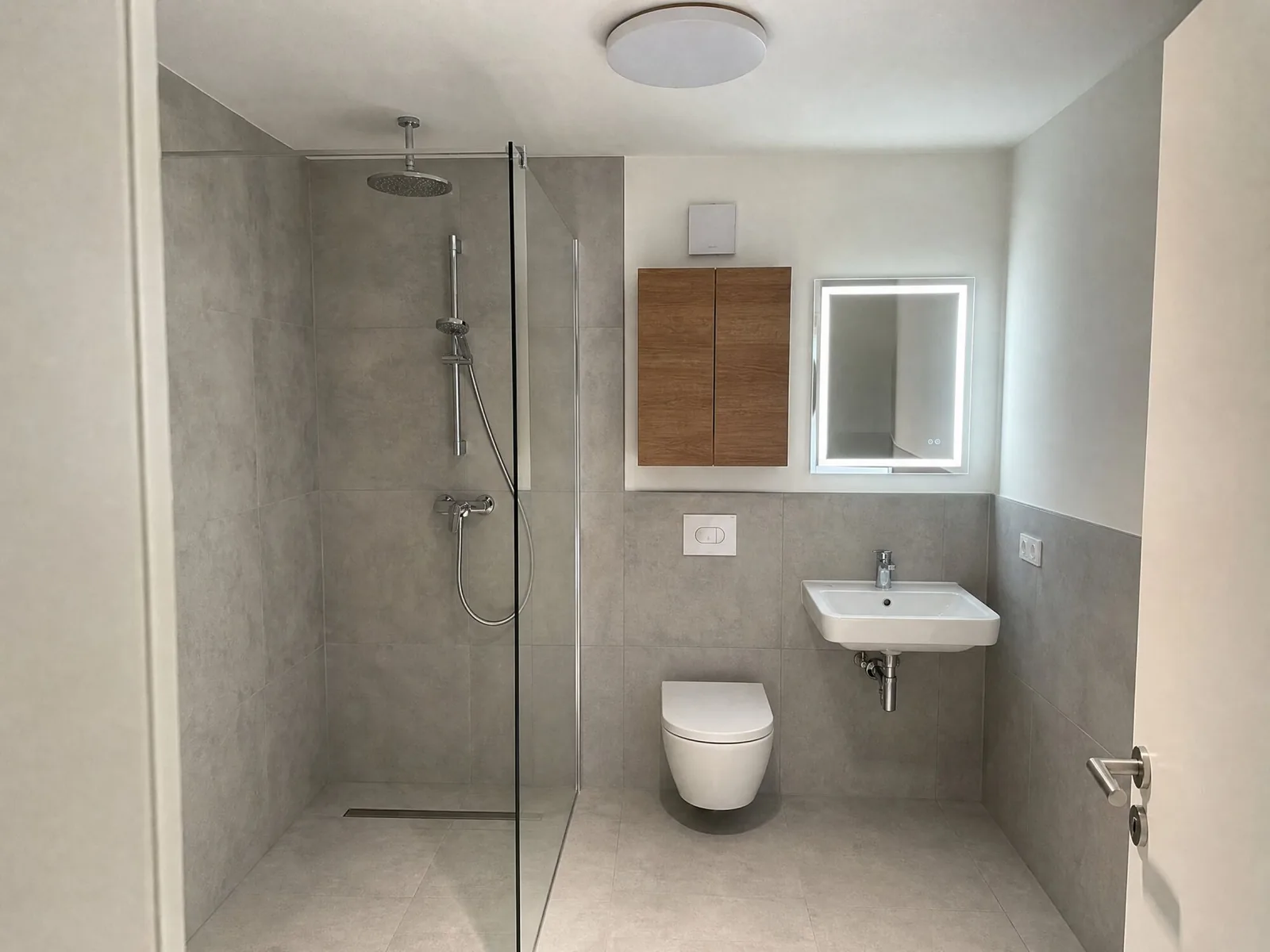 Bad in Betonoptik mit bodengleicher Dusche, WC und Waschbecken