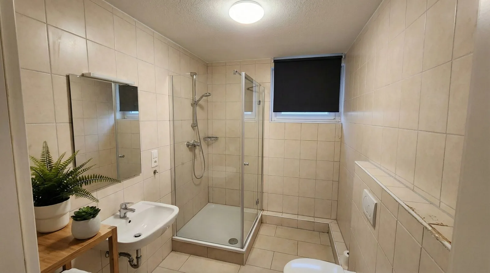 Duschbad mit Glasabtrennung, Waschbecken und Spiegel